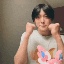 a young man is holding a stuffed animal and making a fist .