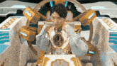 a man in a futuristic costume is sitting in a chair with his arms outstretched