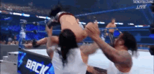 a wrestler is being lifted in the air by another wrestler during a match .