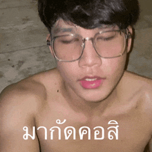 a shirtless man wearing glasses has a foreign language written above his face