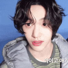 a close up of a person 's face with a blue background and the words " 아이고 애기 " on the bottom right