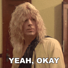 a man with blonde hair says yeah okay in front of him