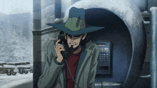 a man with a beard is talking on a payphone