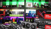 a bunch of graphics cards are sitting on a table in front of a shelf