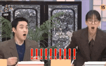 a man and a woman are sitting at a table with their mouths open and one of them is screaming .