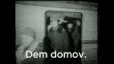 a black and white photo of people getting on a train with the words " dem domov " in white letters