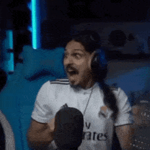 a man wearing headphones is sitting in front of a microphone .