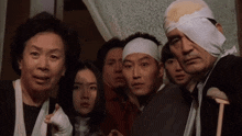 a group of people with bandages on their heads are looking at something