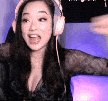 a woman wearing headphones and a black shirt is making a funny face
