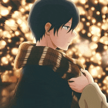 a man with a scarf around his neck is standing in front of a christmas tree