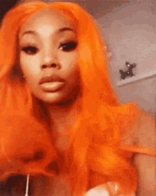 a woman with long orange hair is taking a selfie .