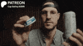 a man wearing glasses and a hat is holding a can of soda and a tube of toothpaste