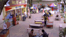 a group of people are sitting at tables in front of a welcome sign