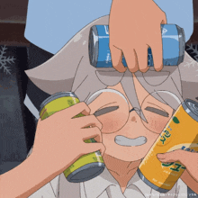a person holding a can of orange juice and another can of green tea