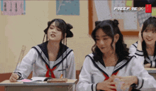 a group of girls are sitting at desks in a classroom with the word freefire x on the bottom right
