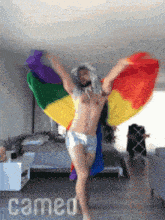a man is dancing with a rainbow flag behind him and the word cameo is on the bottom