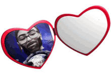 a heart shaped mirror has a picture of a man with glasses holding a globe