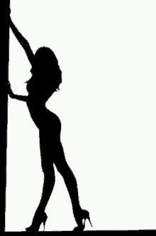 a silhouette of a woman standing next to a pole .