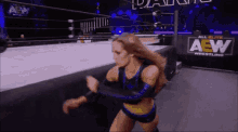 a woman is wrestling in a ring with a sign that says aew wrestling .