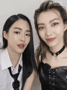 two women are standing next to each other and one has a choker around her neck ..