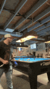a man is playing pool in a room with a pool table that says ' diamonds ' on it