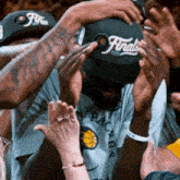 a man wearing a hat that says finals is surrounded by people