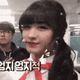 a girl with pigtails is giving a thumbs up