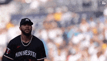 a baseball player for the minnesota twins is standing on the field .
