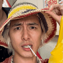 a man wearing a hat with a cigarette in his mouth
