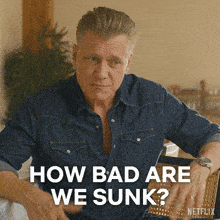 a man in a denim shirt with the words how bad are we sunk