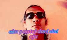 a man wearing sunglasses with the words aku pantai dari sini