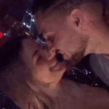 a man and woman kissing in a dark room