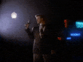 a man in a suit is holding a flashlight in his hand