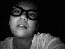 a woman wearing glasses and a bandana looks at the camera