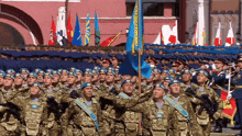 a group of soldiers marching in a parade with one wearing a badge that says ' kazakhstan '