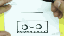 a person is drawing a cartoon face on a piece of paper with a marker