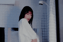 a woman is taking a shower in a bathroom with a shower head
