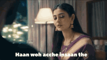a woman in a purple saree is talking to a man and the words haan woh acche insan the are on the screen