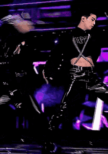 a man in a black jacket is dancing on a stage .