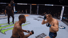 two men are fighting in a boxing ring with ufc written on the floor