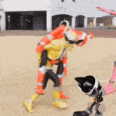 a man in a yellow and red costume is carrying another man on his back .