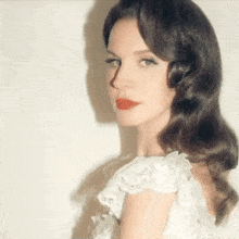 a woman wearing a white dress and red lipstick