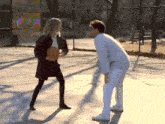a man and a woman playing basketball on a court