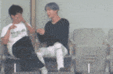 two men are sitting in chairs talking to each other in a stadium .