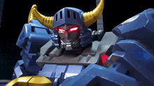 a close up of a robot with red eyes and yellow horns