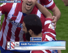 a soccer player named gabi fernandez is celebrating a goal with his teammates