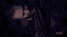 a man with a beard is sitting in front of a fireplace in the dark .