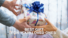 a person giving a gift to another person with the words best gift for your loved ones
