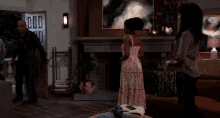 a woman in a pink dress is standing in a living room