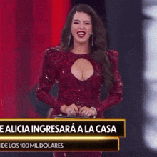 a woman in a red dress is standing in front of a sign that says ' e alicia ingresara a la casa '